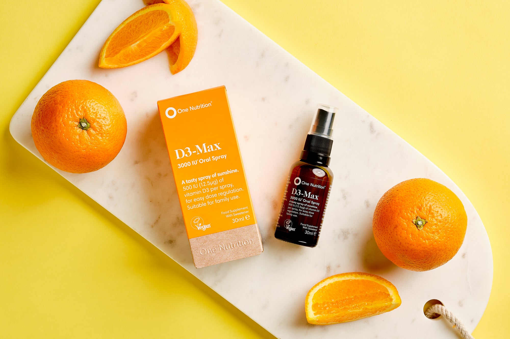 D3-Max supplement bottle and packaging with oranges on a yellow background