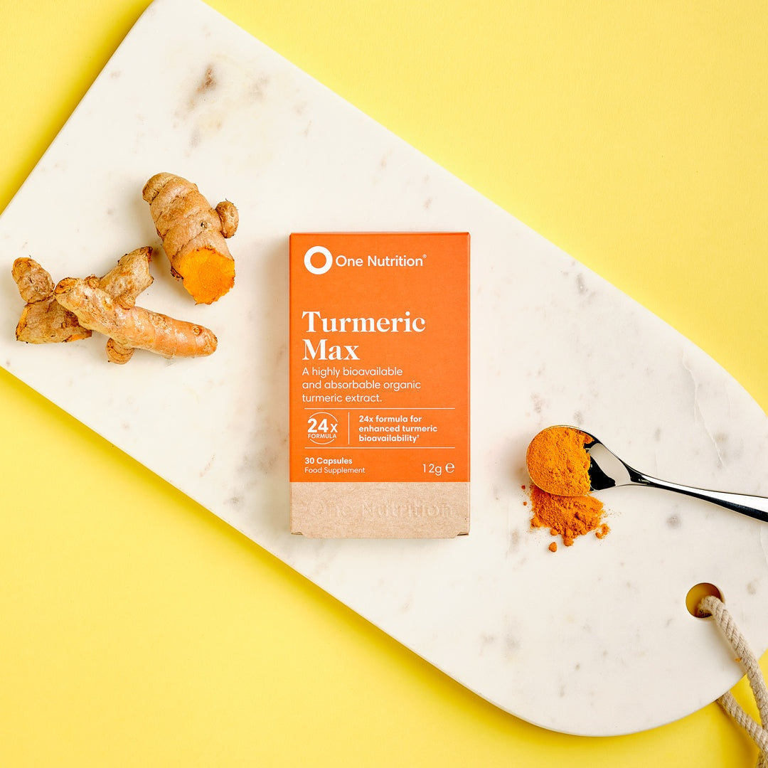 One Nutrition Turmeric Max supplement with turmeric root and powder on white marble board